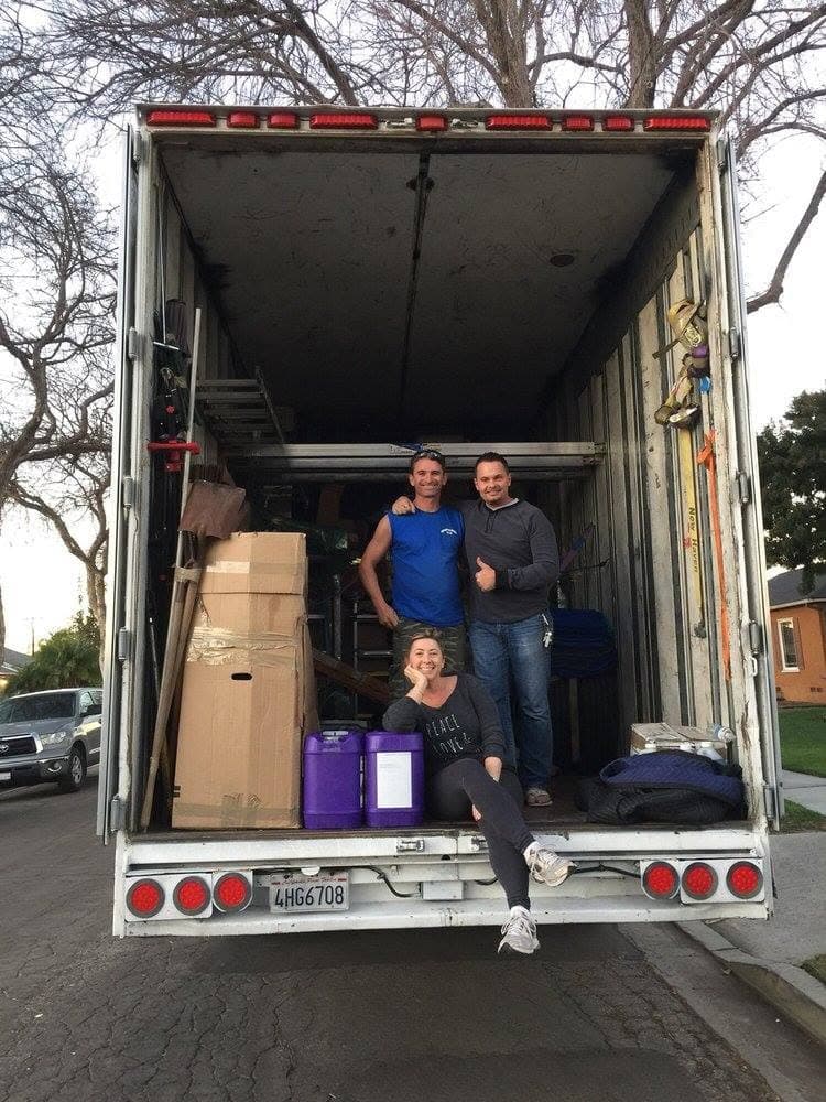 Moving Pro Inc crew and customer at the back of a loaded truck