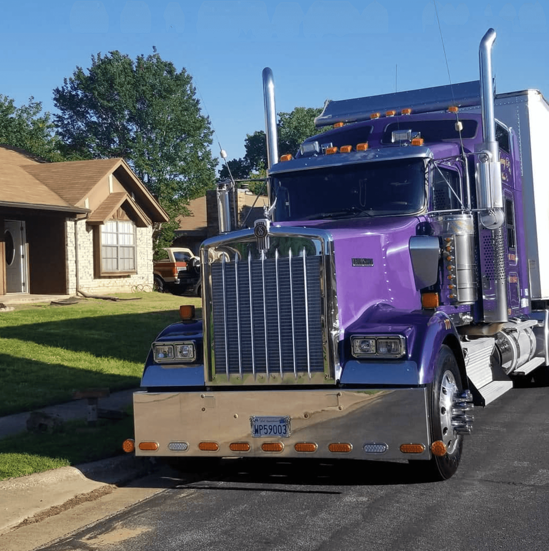 Moving Pro Inc purple Kenworth truck front view at residential delivery
