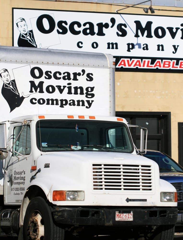 Oscar's Moving Company trucks at headquarters with signage